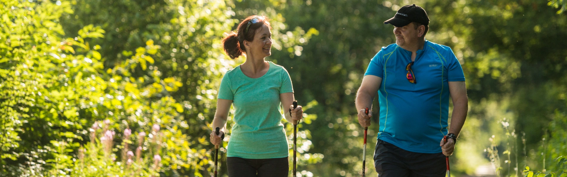 zwei Personen die Nordic Walking betreiben