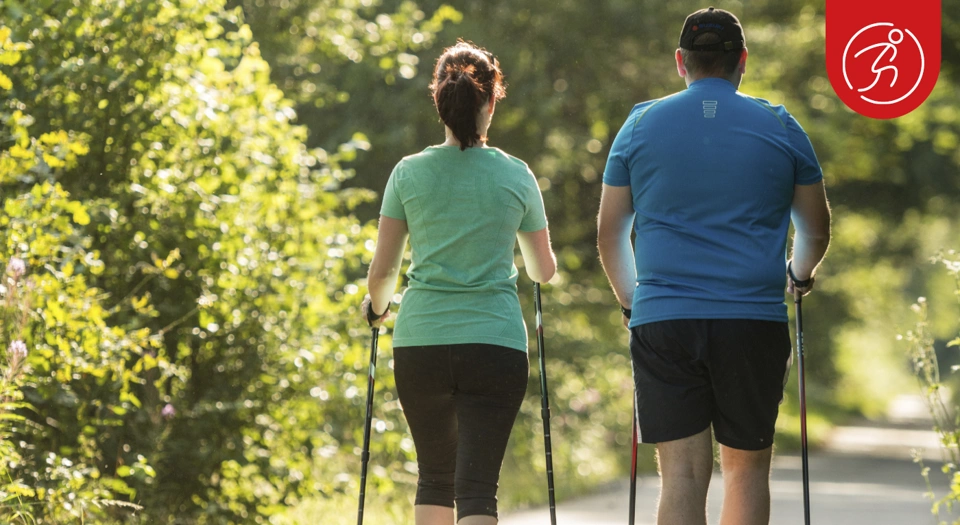 2 Personen laufen mit Nordic-Walking Stöcken 2 Personen laufen mit Nordic-Walking Stöcken